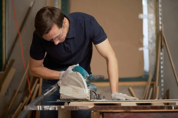 Brunet mannenwerk aan decoupeerzaag in werkplaats, close-up — Stockfoto