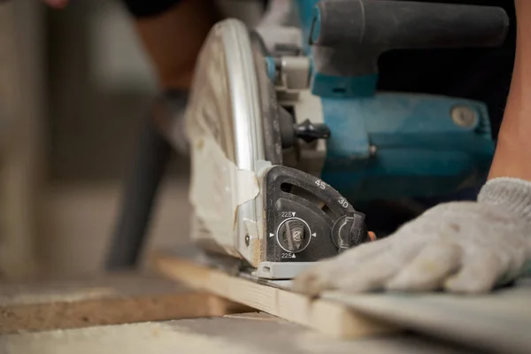 Hands of carpenter sawing wooden boards with jigsaw — Stock Photo, Image