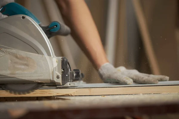 Timmerman in witte handschoenen werkt op decoupeerzaag — Stockfoto