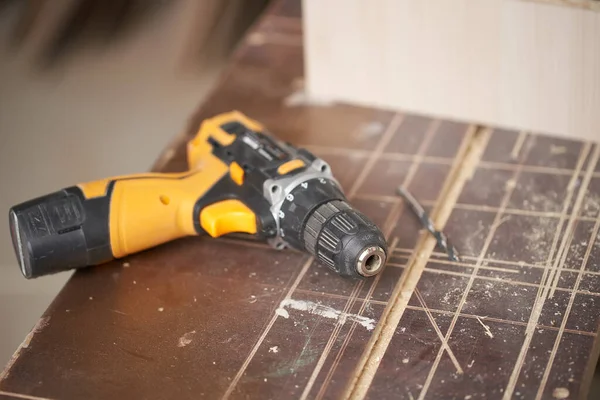 Perceuse avec planche en bois dans l'atelier, gros plan — Photo