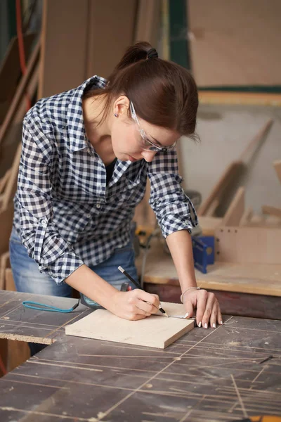 Gözlüklü marangoz kadını şerit ve tahtayla kapatın. — Stok fotoğraf