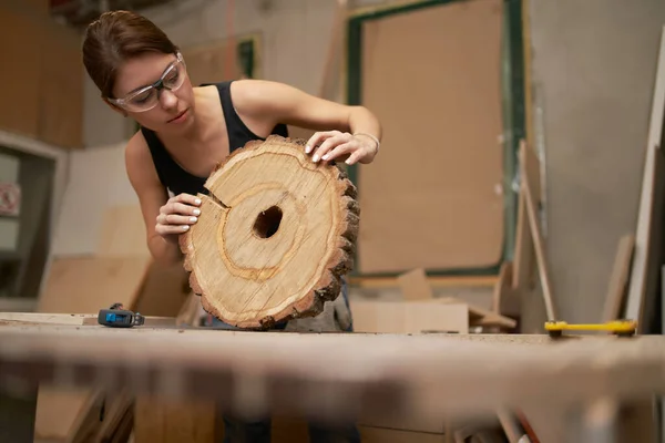 Γυναίκα ξυλουργός σε γυαλιά με μέτρο ταινία και πριόνι κομμένα δέντρο στα χέρια της — Φωτογραφία Αρχείου