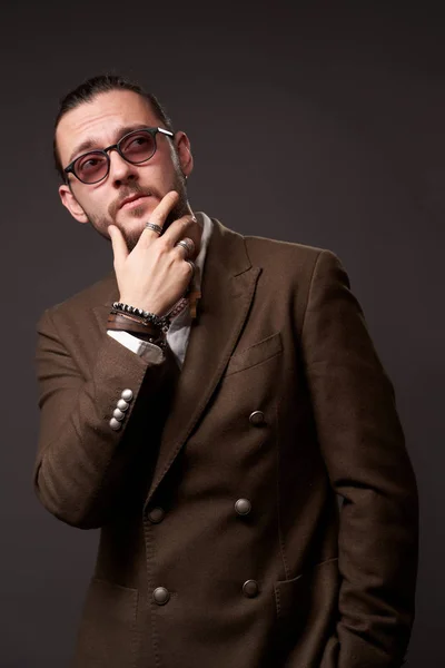 Pensive man with beard in jacket on blank brown background — Stock Photo, Image