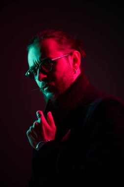 Siyah arka planda gözlüklü genç adam portresi,