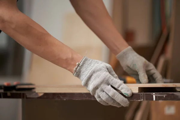 Male carpenter holds board in workshop — Stockfoto