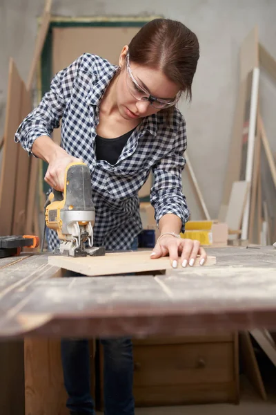 Brunette timmerman werkt met fretsaw — Stockfoto