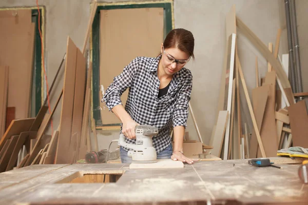 Jonge vrouw timmerman werken met fretsaw — Stockfoto