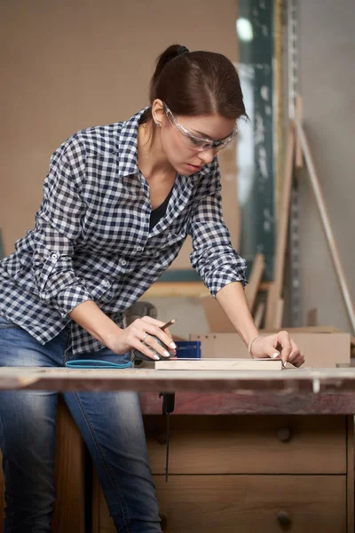 Metresi ve tahtası olan kadın marangoz. — Stok fotoğraf