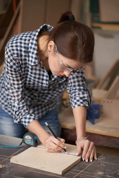 Gözlüklü genç marangoz kadını şerit ve karatahtayla kapatın. — Stok fotoğraf