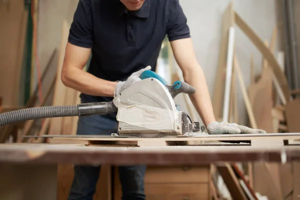 Man met witte handschoenen werkt aan decoupeerzaag in werkplaats — Stockfoto