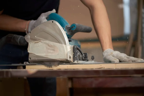 Carpenter man in white gloves works on jigsaw — Stock Photo, Image