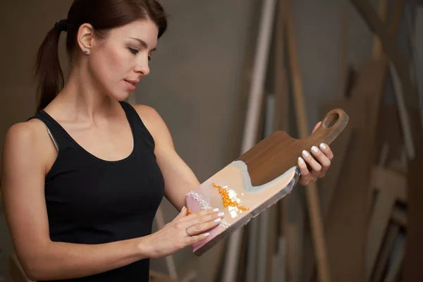 Brunette met foto op snijplank zit op tafel — Stockfoto