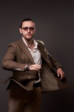 Sakallı erkek, kahverengi arka planda hareket halinde.