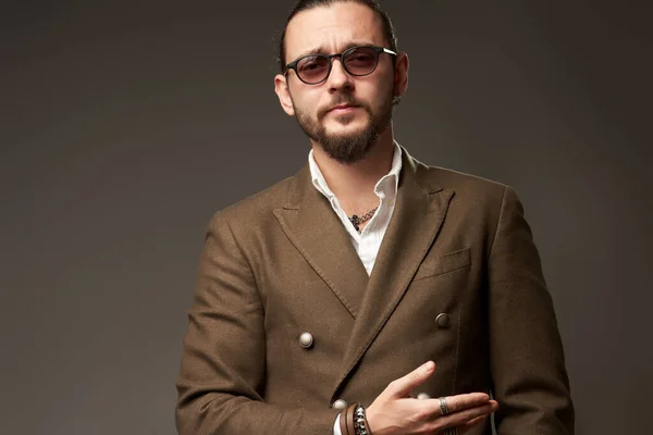 Портрет серьезного человека в куртке на коричневом фоне в студии — стоковое фото