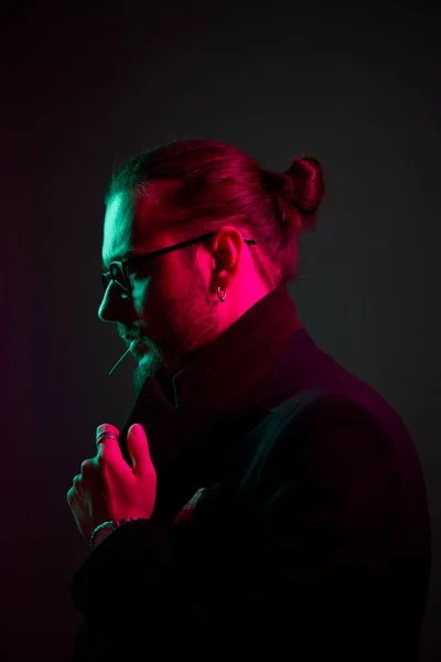 Hombre con barba en gafas en chaqueta sobre fondo negro — Foto de Stock
