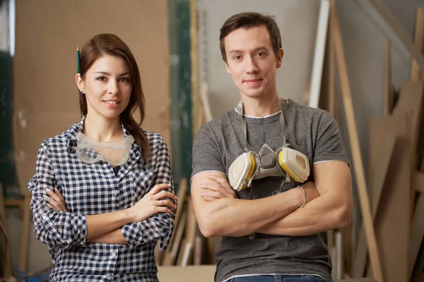 Young couple joiners with arms crossed looking at camera — Stockfoto