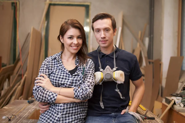 Smiling couple joiners sitting in workshop — Stockfoto