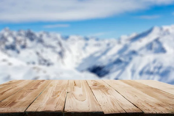 Empty wooden surface on background of snowy highlands in afternoon. — Stockfoto