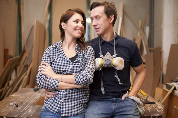 Loving couple joiners sitting in workshop. — Stockfoto