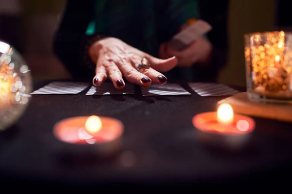 Close-up tangan dengan cincin peramal, kartu ramalan keberuntungan, bola prediksi di atas meja hitam — Stok Foto
