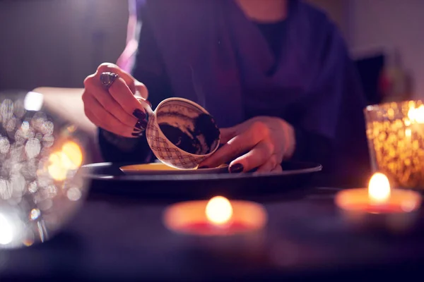 Fortune teller divines on coffee grounds at table with ball of predictions — Stock Photo, Image