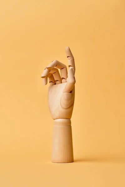 Mão de madeira isolada no fundo laranja — Fotografia de Stock
