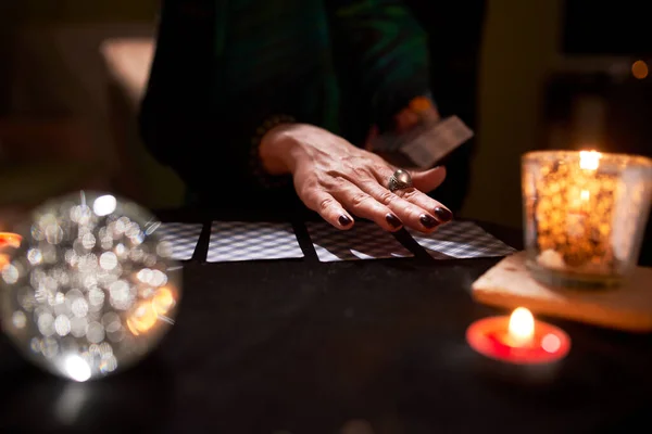 Großaufnahme der Hände von Wahrsagern, Wahrsagerkarten, Ball der Vorhersagen auf schwarzem Tisch — Stockfoto