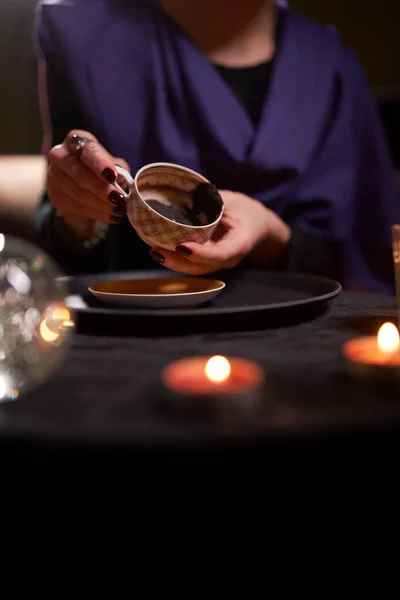 Close-up of female fortunetellers hands divining on coffee grounds at table with predictive ball — Stock Photo, Image