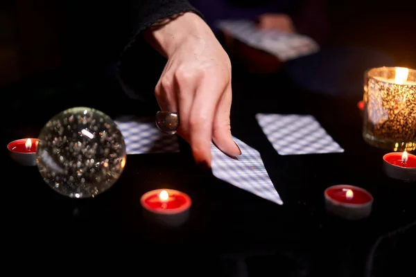 Fortuneteller γυναίκα μαντεύει στα χαρτιά κάθεται στο τραπέζι με κεριά — Φωτογραφία Αρχείου