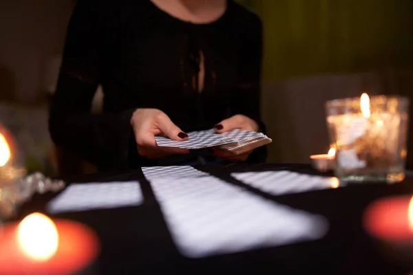 Close-up of fortunetellers hands with cards at table with candles — Stock Photo, Image