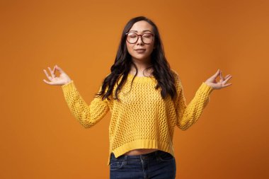 Gözlükleri kapalı, ceketi ceketi stüdyoda olan Doğulu bir kadın.