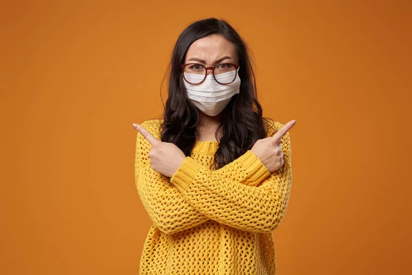 Woman with glasses and medical mask with arms crossed in studio — Stock Photo, Image