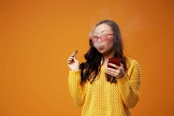 Roken aziatische vrouw in bril met telefoon in haar hand — Stockfoto