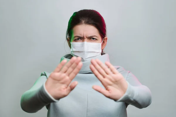 Femme en masque médical avec les bras tendus isolé en studio — Photo