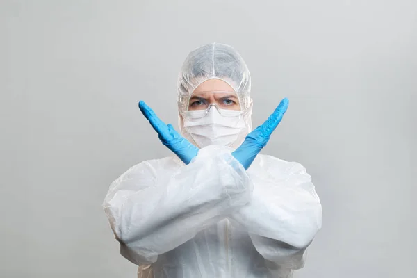 Menselijk in beschermend pak, medisch masker, bril met gekruiste armen. geïsoleerd in de studio. — Stockfoto