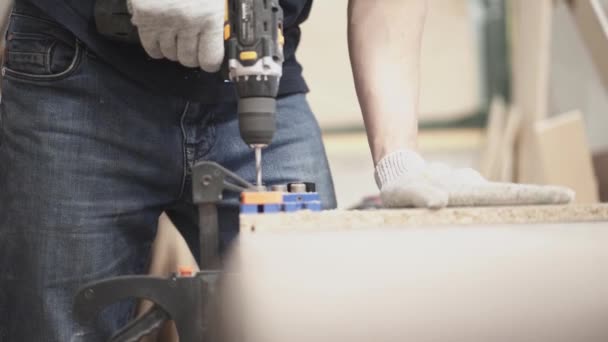 Joiner trabaja con un taladro inalámbrico en su taller . — Vídeo de stock