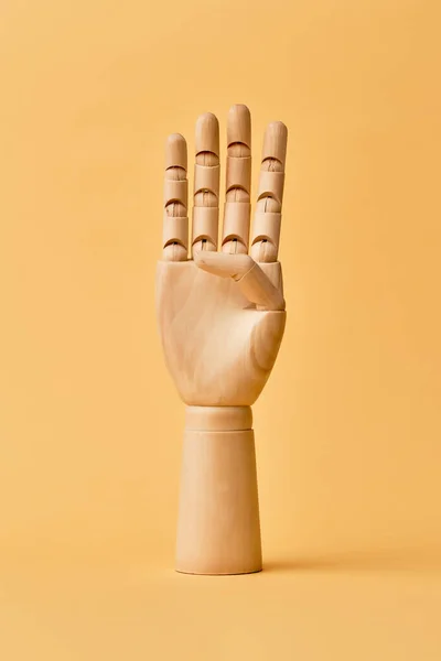 Mão humana de madeira com quatro dedos levantados — Fotografia de Stock
