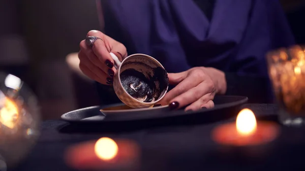 Female fortune teller divines on coffee grounds at table with ball of predictions — Stock Photo, Image