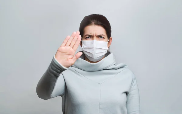 Frau in medizinischer Maske mit ausgestrecktem Arm isoliert im Studio — Stockfoto