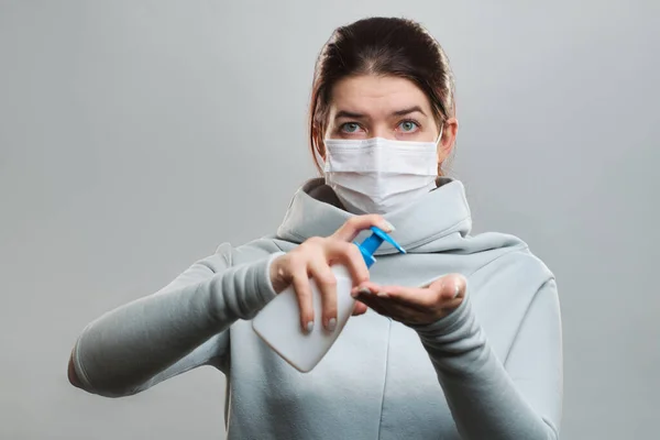 Closeup of brunette woman in medical mask with liquid soap in hands isolated in studio — Stock Photo, Image