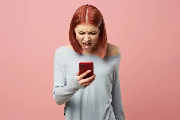 Jonge vrouw met telefoon in haar handen staan in studio — Stockfoto