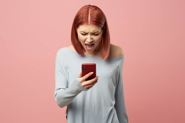 Young woman with phone in her hands standing in studio