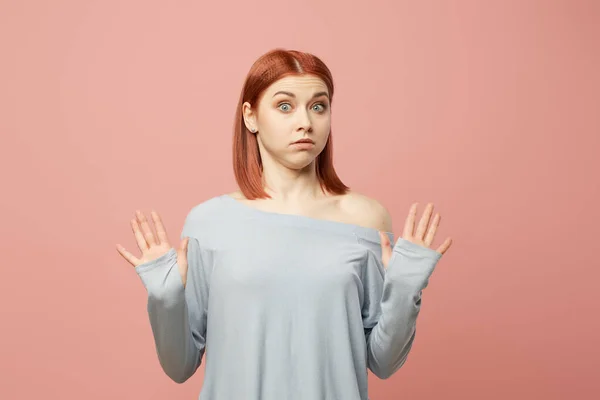 Jonge vrouw in grijze trui staande in studio — Stockfoto