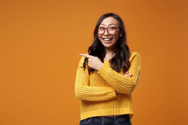 Gözlüklü ve ceketli mutlu kadın stüdyoda el ele tutuşuyor.