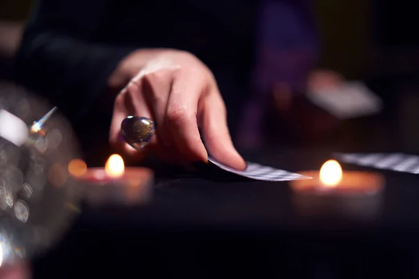 Close-up of woman fortunetellers hands with fortune-telling cards at table with candles — Stock Photo, Image