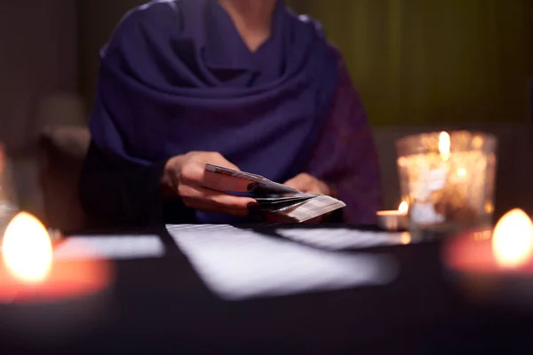 Primer plano de la mujer adivinos manos con tarjetas en la mesa con velas — Foto de Stock