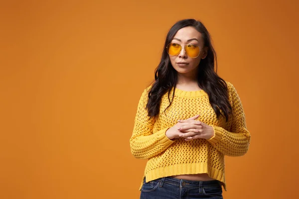 Mujer oriental en gafas amarillas en suéter estudio — Foto de Stock