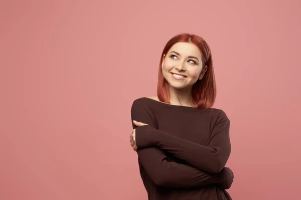 Glimlachende jonge vrouw met grijze ogen met gekruiste armen — Stockfoto