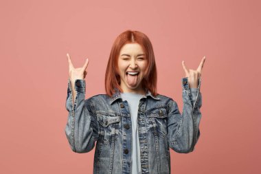 Kot ceketli genç punk kız stüdyoda duruyor.