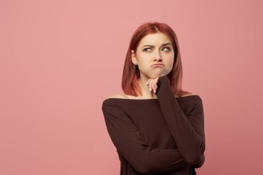 Gri gözlü, kolları çapraz kızıl bir kadın.